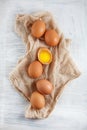 Brown hen`s eggs one egg yolk visible decorated on napkin Royalty Free Stock Photo