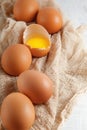 Brown hen`s eggs one egg yolk visible decorated on napkin Royalty Free Stock Photo