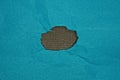 brown hole in a piece of blue paper cardboard Royalty Free Stock Photo
