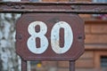 A brown house number plaque, showing the number eighty Royalty Free Stock Photo