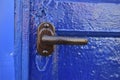 A brown iron handle on a freshly painted blue door Royalty Free Stock Photo