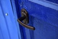 A brown iron handle on a freshly painted blue door Royalty Free Stock Photo