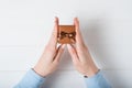 Brown jewelry box in female hands. Present. White background