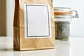 Brown bag in front of bale glass with dried tea leaves