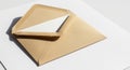 A brown kraft paper envelope is placed on a plain white surface. The envelope is open, Royalty Free Stock Photo