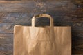 Brown kraft paper grocery shopping bag on wooden background. Plastic-free alternatives zero waste environmental protection Royalty Free Stock Photo