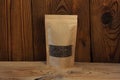 Brown kraft paper pouch bags with coffee beans front view on a wooden background Royalty Free Stock Photo
