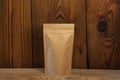 Brown kraft paper pouch bags with coffee beans front view on a wooden background. Packaging for foods and goods Royalty Free Stock Photo