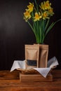 Brown kraft paper pouch bags with coffee beans and tea leaves in wicker basket with white textile on wooden background Royalty Free Stock Photo