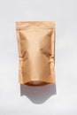 Brown kraft paper pouch bags with coffee beans top view with shadow isolated on white background.Food packaging flat lay