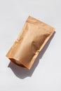 Brown kraft paper pouch bags with coffee beans top view with shadow on white background.Food packaging flat lay