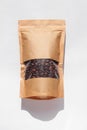 Brown kraft paper pouch bags with coffee beans top view with shadow on white background.Food packaging flat lay