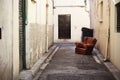 Brown leather armchair abandoned on the narrow old town street