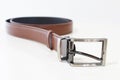 Brown leather belt isolated on white. Rolled male belt