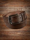 Brown leather belt on a wooden brown background