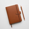Brown leather-bound notebook with a strap and a brass button on a white surface Royalty Free Stock Photo