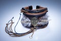 Brown leather bracelet with metal pendant and feathers