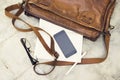 Brown leather handbag, blank cell phone, diary and glasses Royalty Free Stock Photo