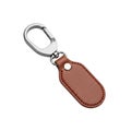 Isolated image showcasing a brown leather keychain with a silver clasp on a white background studio shot Royalty Free Stock Photo