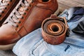 Brown leather men`s boots, belt, sunglasses and blue jeans, close up Royalty Free Stock Photo