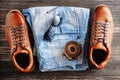 Brown leather men`s boots, belt, sunglasses and blue jeans on a dark wooden background, top view Royalty Free Stock Photo