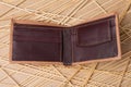 Brown leather men`s purse on a textured wooden background, the wallet is open Royalty Free Stock Photo