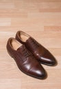 Brown leather men shoes on wooden ground Royalty Free Stock Photo