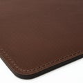 Brown leather mouse pad with rounded corners, stitched edges, and a smooth texture.