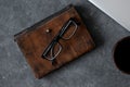 Brown leather notebook, pen, laptop and glasses on gray background Royalty Free Stock Photo