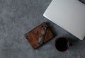 Brown leather notebook, pen, laptop and glasses on gray background Royalty Free Stock Photo