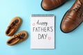 Brown leather shoes, children`s shoes and notebook with inscription happy fathers day on color background