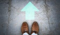 Brown leather shoes and green chalky arrows on asphalt