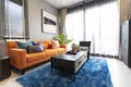 Brown leather sofa with blue and orange pillow in entertainment of luxury home.