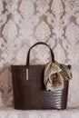 Brown leather vintage bag on a beige background with brown spots, vintage crocodile leather bag front view, ladies crocodile leath Royalty Free Stock Photo