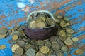 brown leather wallet with a bunch of old coins on a blue rubbed wooden table Royalty Free Stock Photo