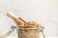 Brown lentils in a crystal jar with a wooden spoon on a kitchen counter Royalty Free Stock Photo