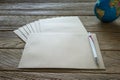 Brown Letter Envelop with globe and pen on wooden table