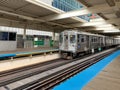 Brown line el train moving into Merchandise Mart station where the platform is empty at midday Royalty Free Stock Photo