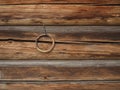 Brown loghouse wall fragment with a metal ring