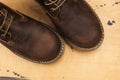 Brown men`s boots, on a wooden background. Closeup Royalty Free Stock Photo