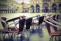 Brown and metal chairs submerged on Venice Square with old toned Royalty Free Stock Photo