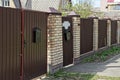 Brown metal gate and door with black mailboxes on the wall Royalty Free Stock Photo