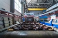 Brown metal roof tiles made from galvanized and painted steel in metal sheet forming machine in metalwork factory Royalty Free Stock Photo