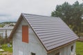 Brown metal tile on the roof of the house. Corrugated metal roof and metal roofing. Modern roof made of met Royalty Free Stock Photo