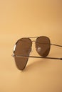 Brown mirrored sunglasses with anti-reflective coating and UV protection on a orange background