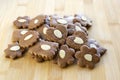 Brown moravian dark gingerbreads with sliced almonds on wooden table, christmas cookies Royalty Free Stock Photo