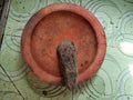 A brown mortar made of clay and a mortar made of natural stone on top of patterned green ceramic