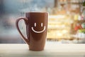 Brown mug of coffee with a happy smile.