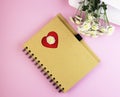 A brown notebook with flowers on a pink background Royalty Free Stock Photo