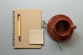 Brown notebook, pen, coffe cup on gray desk background. workspace. flat lay, top view, copy space Royalty Free Stock Photo